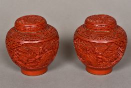 A pair of Chinese red cinnabar lacquer vases and covers Both typically worked with floral vignettes