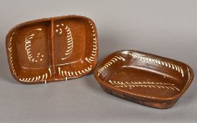 Two slipware pottery dishes Each of rounded rectangular form, one with twin divisions.