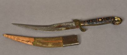 An early horn handled dagger The curved blade pierced, the pistol grip handle variously inlaid.