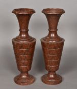 A pair of 19th century carved red marble urns Each with flared rim and ribbed tapering body.
