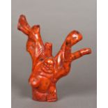 A Chinese carved red coral figure Modelled as Buddha holding a jar. 15.5 cm high.