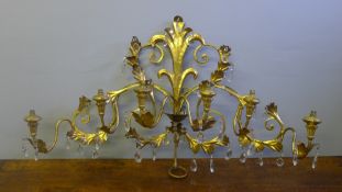 An Italian gilt metal six branch wall light Of scroll design with faceted glass drops. 107 cm wide.