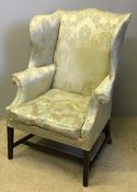 A George III mahogany framed winged back armchair Of typical form with scrolling arms,