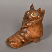 A late 19th century Blackforest carved inkwell Formed as a kitten in a boot, with glass inset eyes.