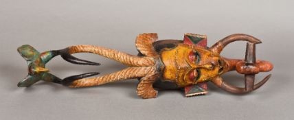 A Guro carved wood and polychrome decorated mask The slender scarified face surmounted with horns