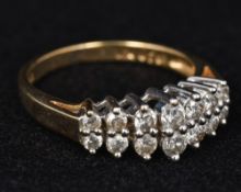 A 9 ct gold fourteen stone diamond ring The claw set stone set in two domed rows totalling