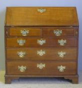 A George III oak bureau The rectangular top above the fall with pierced brass escutcheon,