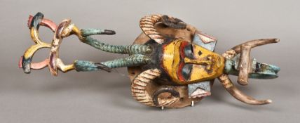 A Guro carved wood and polychrome decorated mask The slender face surmounted with horns and a pair