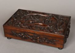 A late 19th century Chinese carved hardwood box Of hinged rectangular form,