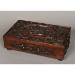 A late 19th century Chinese carved hardwood box Of hinged rectangular form,