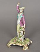 An 18th century Chelsea porcelain figure of a gardener Modelled with one arm raised and holding a