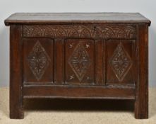 A 18th century carved oak three panel coffer The hinged moulded top enclosing a candle box,