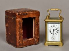 A miniature brass cased carriage alarm clock The white enamelled dial with Roman numerals and