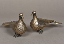 A pair of Iranian silver bird figures Naturalistically modelled with turquoise eyes. 11 cm high.