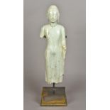 A Chinese Ming carved green hardstone Buddha Modelled standing in flowing robes,