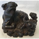 A Chinese carved hardwood group Worked as a recumbent water buffalo and temple lion. 10.5 cm high.