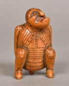 An early 19th century carved treen figural snuff box Formed as a squatting defecating gentleman,