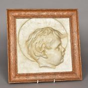 An early 20th century plaster profile portrait plaque of a child Oak framed. 36 cm square overall.