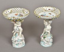 A pair of early 20th century Continental porcelain figural tazzas Each with floral painted and