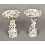 A pair of early 20th century Continental porcelain figural tazzas Each with floral painted and