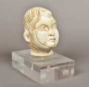 A carved white marble head, possibly Roman (100-300 AD) Mounted on a perspex base. 20.5 cm high.