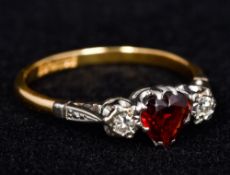 An 18 ct gold and platinum diamond and garnet three stone ring Centrally set with a faceted heart