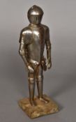 A toy suit of armour Presented on a small manakin, standing on a plinth base. 30 cm high overall.