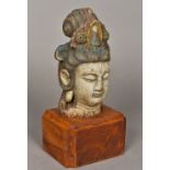 A Chinese carved wood and polychrome decorated Buddha's head Mounted on a later plinth base. 29.