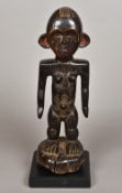 An antique African tribal carved wooden figure Modelled as a female with stylised face,