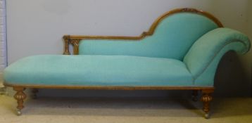 A Victorian oak framed chaise longue The shaped padded back above the overstuffed seat with