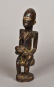 An antique African tribal carved wooden figural group Formed as a woman holding an infant.