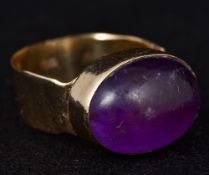 A 9 ct gold amethyst set ring The stone cabochon cut.