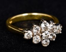 An 18 ct gold nine stone cluster ring 1.5 cm wide.