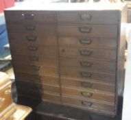 An early 20th century oak bank of eighteen drawers