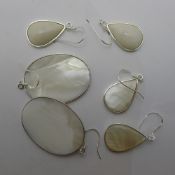 Three pairs of silver and shell earrings
