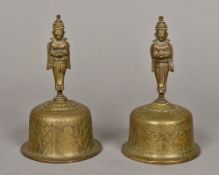 A pair of Eastern brass hand bells Each with engraved bowl and figural cast handle. 18.5 cm high.