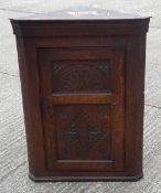 A Victorian carved oak corner cupboard