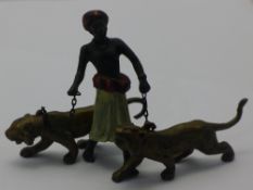 A cold painted bronze model of a North African gentleman and tigers