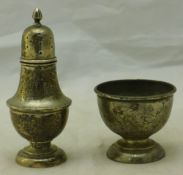 A silver egg cup and pepper