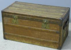 A late 19th century French travelling trunk Of wooden banded form with brass lock plates.