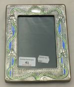An Art Nouveau style sterling silver and enamel photograph frame