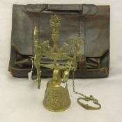 A leather satchel and a brass bell