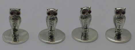 A set of four silver owl menu holders