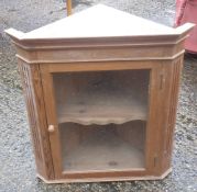 A modern glazed pine hanging corner cupboard