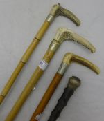 Three antler handled riding crops and a walking stick