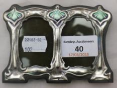 An Art Nouveau style sterling silver and enamel double photograph frame