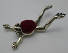 A silver pin cushion in the form of a frog