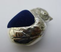 A silver pin cushion in the form of a chick