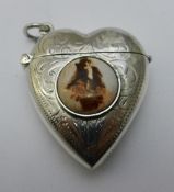 A silver heart shaped vesta depicting a girl