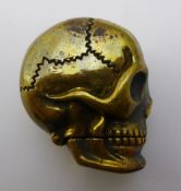 A brass vesta in the shape of a skull